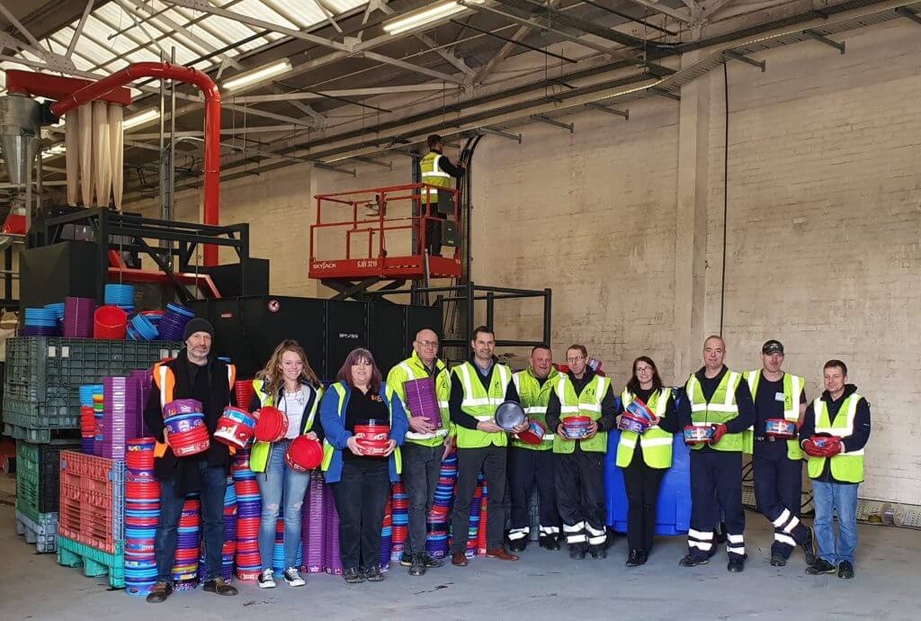 dcw employees holding recycled tubs cropped